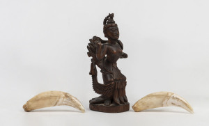 A pair of antique tiger teeth together with an antique Indian carved deity statue (3 items), 19th century the teeth 9.5cm long, the statue 15cm high. PROVENANCE Private Collection, Melbourne. Originally collected by an English Army Major in India during the 1870s. ♦ May be subject to export/import restrictions
