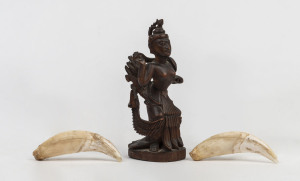 A pair of antique tiger teeth together with an antique Indian carved deity statue (3 items), 19th century the teeth 9.5cm long, the statue 15cm high. PROVENANCE Private Collection, Melbourne. Originally collected by an English Army Major in India during 