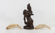 A pair of antique tiger teeth together with an antique Indian carved deity statue (3 items), 19th century the teeth 9.5cm long, the statue 15cm high. PROVENANCE Private Collection, Melbourne. Originally collected by an English Army Major in India during