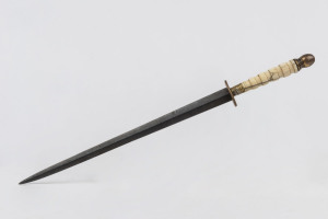 An antique German paper knife, marine ivory handle with steel blade and cast metal fittings, 19th century, 35cm long