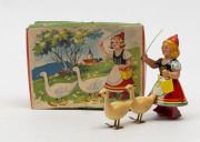 KOHLER:- Boxed - clockwork tin plate "Swiss Maid" with two geese, brightly painted original colours, in original box; missing key, c.1950s, length 17cm.