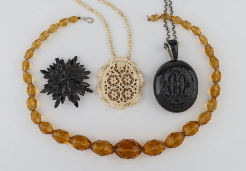 A vintage amber crystal necklace, an antique carved ivory necklace and pendant, a jet star brooch and an antique mourning locket on chain, ​(4 items), 19th and early 20th century,