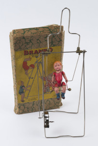 BRANCO: - Boxed - "Mechanical Acrobat"; wind-up mechanisim with originial celluloid acrobat (15cm tall); acrobat swings vigorously when mechanism activated c. 1950s, with original illustrated box, 18 x 33cm.