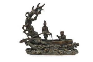 An antique Chinese bronze statue of figures in a boat, 18th/19th century, ​15cm high, 17cm wide