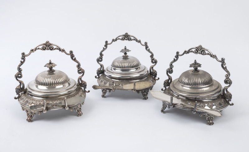 Three antique silver plated butter dishes with glass liners and knives, 19th century, the largest 18cm high, 20cm wide