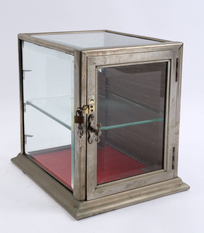 A small antique countertop display cabinet, nickel bound with bevelled glass, late 19th century, ​34cm high, 29cm wide, 35cm deep