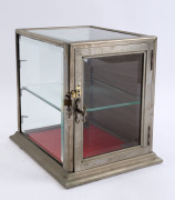 A small antique countertop display cabinet, nickel bound with bevelled glass, late 19th century, ​34cm high, 29cm wide, 35cm deep