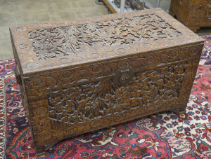 A Chinese carved camphor wood trunk with side handles, 20th century, 60cm high, 106cm wide, 52cm deep