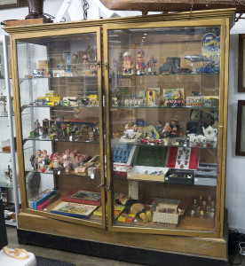 An antique two door upright shop display cabinet, glass replaced with ply in the back, early 20th century, 200cm high, 200cm wide, 70cm deep