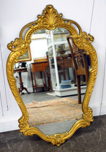 An Italian wall mirror, gilt finished cast resin and glass, circa 1950s, ​90 x 58cm