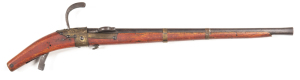 INDIAN TRIBAL MATCHLOCK S/B PISTOL: 20" swamped iron barrel; poor bore; crude matchlock system with brass fittings; aged patina to barrel & matchlock fittings; full length stock with a reddish finish; w.o. A good decorator for a man cave. C.1820 