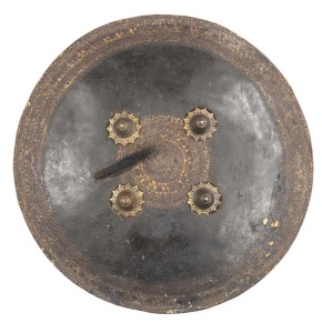 INDIAN DHAL HIDE SHIELD: 21" in diameter with 4 central ornate brass bosses & an ornate border edging; faded reddish colour to backing with strap rings, one missing. Looks good. Mid-19th C.