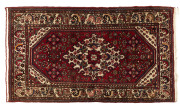 A Persian hand-woven rug with red background, 20th century, 202 x 110cm