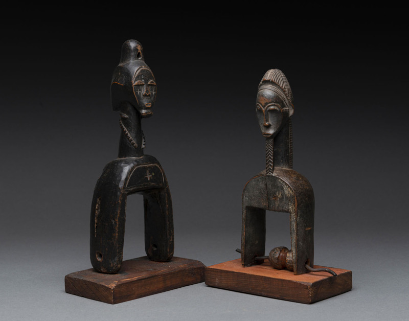 Two African weaving pulleys one with original spool, carved wood, Baule tribe, Ivory Coast, on later wooden plinths, 21cm and 24.5cm high overall