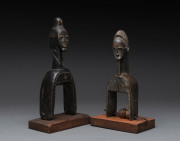 Two African weaving pulleys one with original spool, carved wood, Baule tribe, Ivory Coast, on later wooden plinths, 21cm and 24.5cm high overall