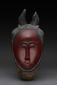 A red face mask with horns, carved wood and painted finish, Baule tribe, Ivory Coast, 39cm high