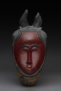 A red face mask with horns, carved wood and painted finish, Baule tribe, Ivory Coast, ​39cm high