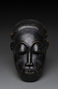 An African face mask, carved wood with patinated finish, Baule tribe, Ivory Coast, 28cm high