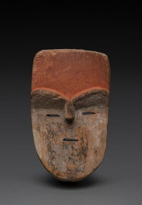 An African mask with orange forehead and slit eyes, carved wood and natural earth pigments, Adouma tribe, Gabon, 28cm high