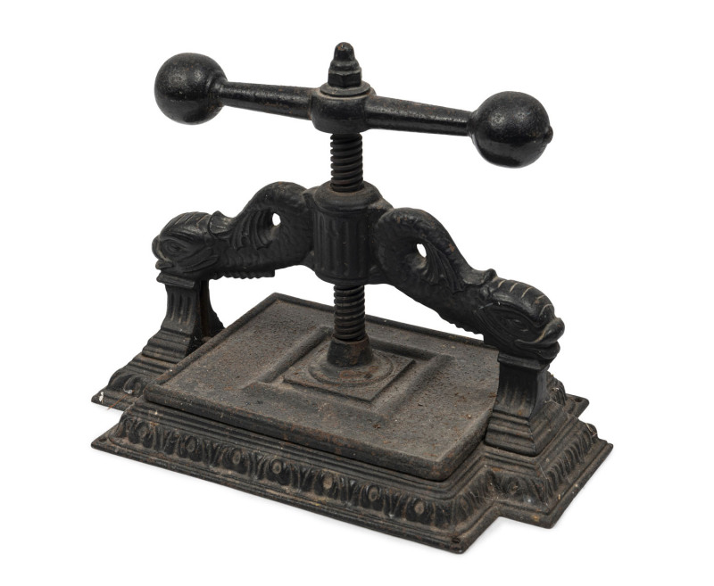 An ornate antique cast iron book press, 19th century, ​35cm high, 46cm wide, 28cm deep