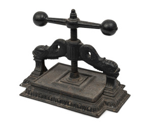An ornate antique cast iron book press, 19th century, 35cm high, 46cm wide, 28cm deep