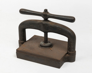 An antique cast iron book press, 19th century, 32cm high, 42cm wide, 25cm deep
