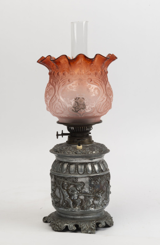 An antique oil lamp with cast metal base, double burner, acid etched ruby glass shade and glass chimney, (electrified), late 19th century, ​52cm high