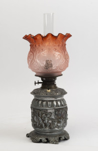 An antique oil lamp with cast metal base, double burner, acid etched ruby glass shade and glass chimney, (electrified), late 19th century, 52cm high