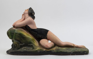 A chalk ware statue of a bathing beauty, circa 1920, 28cm high, 46cm long