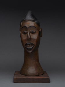 Male bust with black discs, carved and painted wood, Ekoi tribe, Nigeria/Cameroon border, on later wooden plinth, 42cm high overall