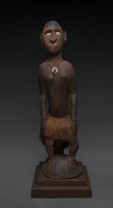 A seated male figure, carved wood, shell, fibre and earth pigment, Papua New Guinea, on later wooden plinth, ​122cm high overall