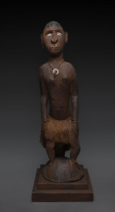 A seated male figure, carved wood, shell, fibre and earth pigment, Papua New Guinea, on later wooden plinth, 122cm high overall