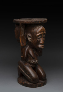 A Chieftain's stool in the long face style, carved wood with remains of piped clay, Baluba tribe, Southern Congo, 44cm high
