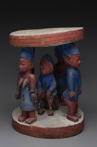 A circular stool with five standing figures, carved and polychrome timber, Yoruba tribe, Nigeria, 49cm high, 37cm wide