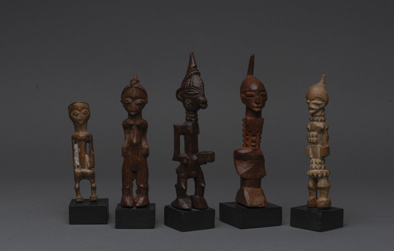 Group of five African tribal statues, carved wood and remains of ochre, later wooden plinths, ​the largest 16cm high