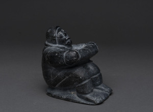 An Inuit seated figure, carved stone, Arctic North America, 10cm high