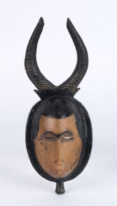 A horned mask, carved wood with painted finish, Baule tribe, Ivory Coast, 31cm high