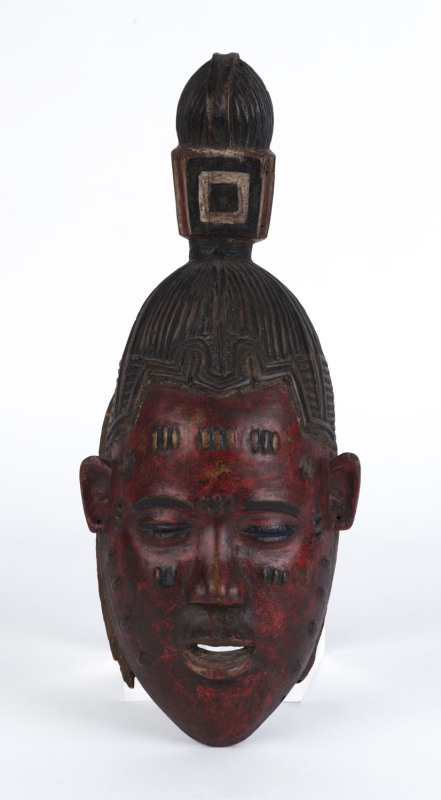 A mask with stylized top knot, carved wood with red and black painted finish, Guru tribe, Ivory Coast, ​40cm high