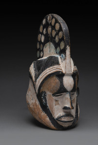 A death mask with spotted head dress, carved wood this black and white painted finish, Ibo tribe, Nigeria, 40cm high