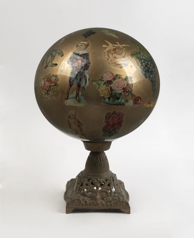 A glass globe with internal découpage decoration on cast metal base, ​45cm high