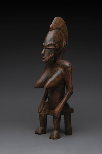 A seated female figure, carved wood with remains of red painted finish, Senufo tribe, Ivory Coast, 48cm high