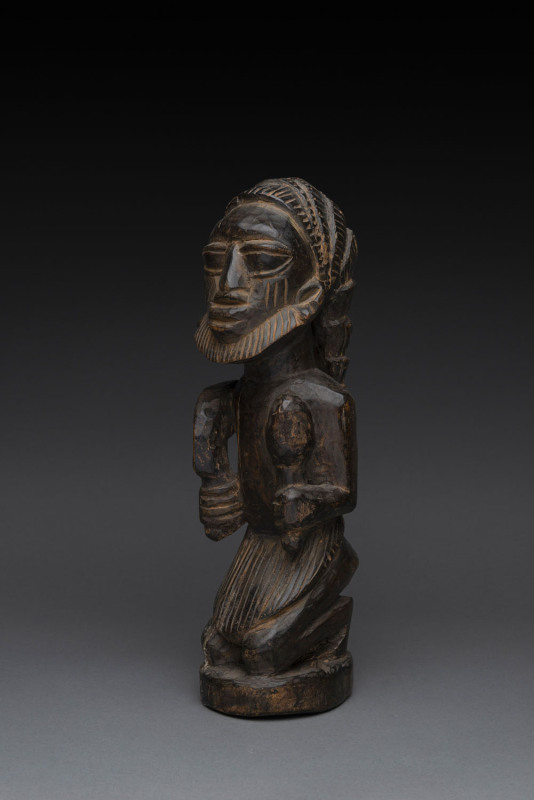 Eshu kneeling figure, carved and patinated wood, Yoruba tribe, Nigeria, ​38cm high