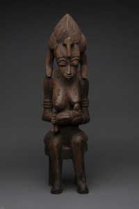 A seated female figure, carved wood with remains of painted decoration, Senufo tribe, Ivory Coast, 58cm high