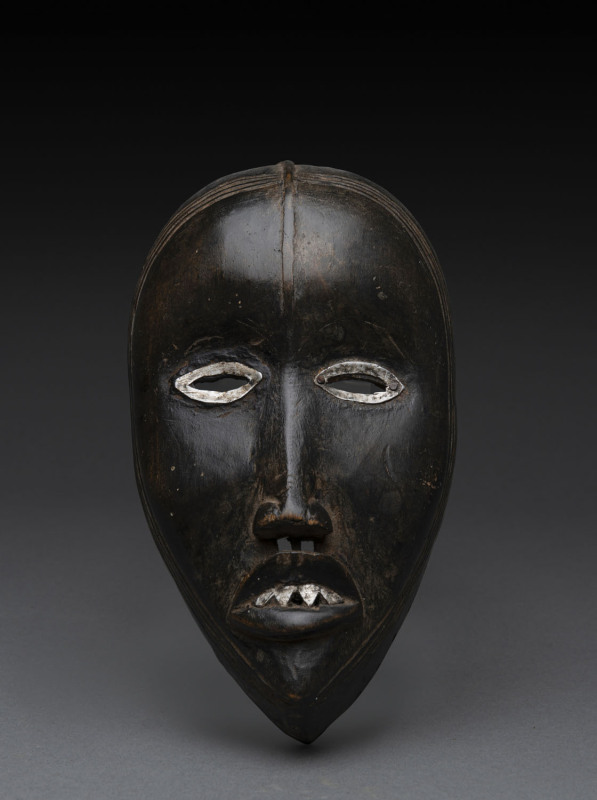 A ceremonial mask, carved and painted wood with metal eyes and teeth, Dan tribe, Ivory coast, ​19cm high