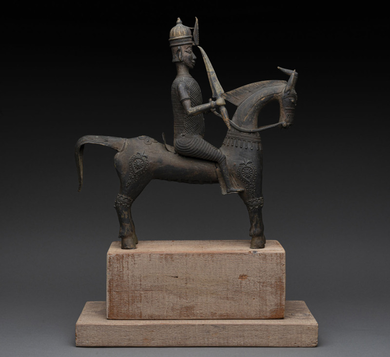 A statue of a warrior on horseback, cast bronze, later wooden base, 40cm high, 39cm long, 58cm high overall