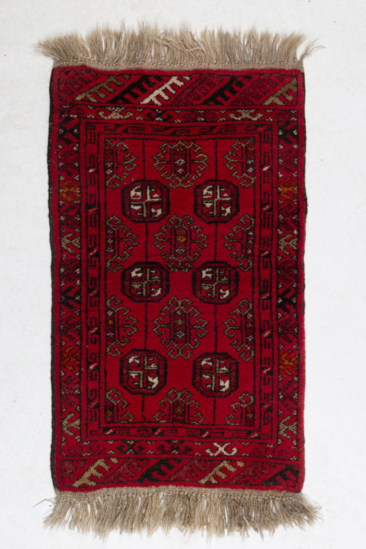 A Turkoman hand-woven red pattern rug, ​100 x 50cm