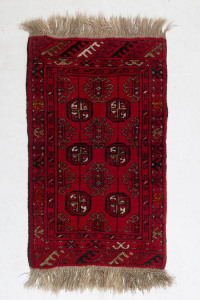 A Turkoman hand-woven red pattern rug, 100 x 50cm