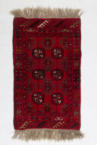 A Turkoman hand-woven red pattern rug, ​100 x 50cm