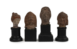 Four Roman-Egyptian miniature busts, terracotta on later wooden bases, 1st to 2nd century A.D. ​the largest 5.5cm high