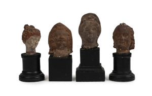 Four Roman-Egyptian miniature busts, terracotta on later wooden bases, 1st to 2nd century A.D. the largest 5.5cm high